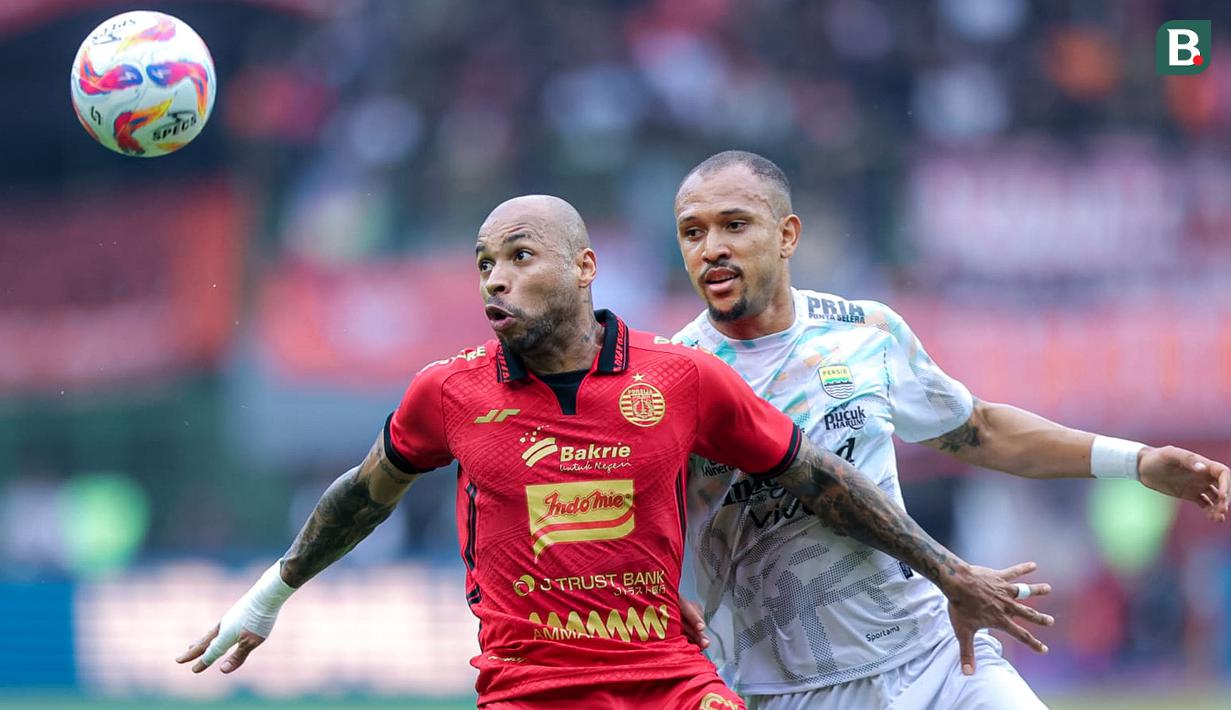 Pemain Persija Jakarta, Gustavo Almeida (kiri) berebut bola dengan pemain Persib Bandung, Gustavo Franca dalam laga lanjutan BRI Liga 1 2024/2025 di Stadion Patriot Candrabhaga, Bekasi, Minggu (16/02/2025). (Bola.com/M Iqbal Ichsan)