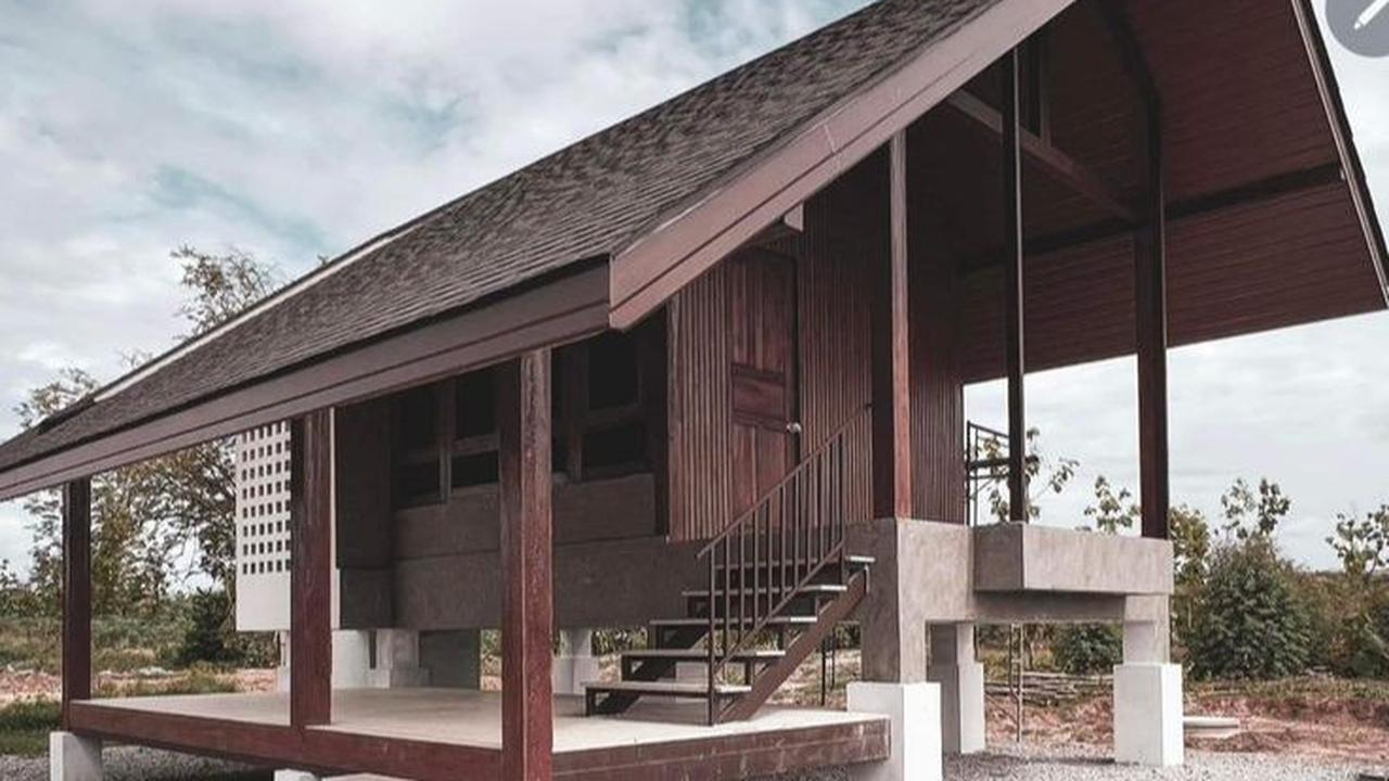 Rumah Kayu dengan Atap Miring dan Warna Kayu Gelap