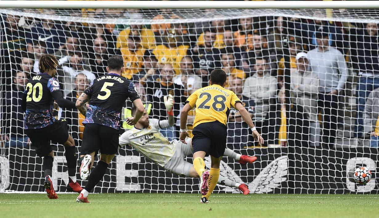 Dele Alli (kiri) menjadi keran gol Tottenham lewat tendangan pinalti setelah dirinya dijatuhkan di kotak dua belas pas. Ia sukses melesatkan bola ke sudut kiri dari arah kiper Wolves, Jose Sa. Papan skor berubah menjadi 1-0 dengan keunggulan The Lilywhites. (Foto: AP/Rui Vieira)