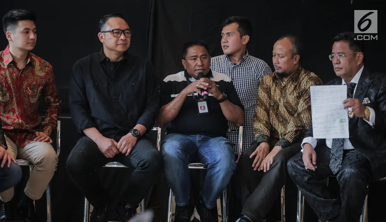 Pengacara Hotman Paris Hutapea (kanan) menunjukkan surat perjanjian perdamaian antara Garuda Indonesia dengan youtuber Rius Vernandes saat Ketua Harian Serikat Karyawan Garuda Indonesia Tomy Tampati (tengah) memberi keterangan pers di Jakarta, Jumat (19/7/2019). (Liputan6.com/Faizal Fanani)