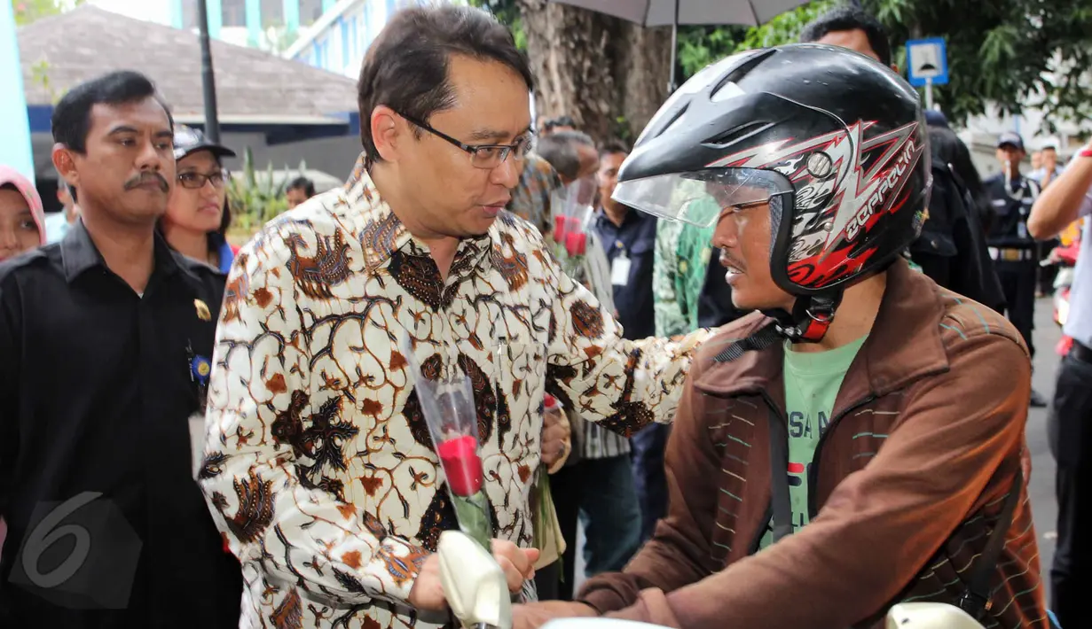 Kepala BPOM RI Roy Sparringa membagikan bunga Mawar di jalan Percetakan Negara  dalam aksi simpatik BPOM RI, Jakarta, Senin (1/6/2015). Kampaye ini dalam dukungan Gerakan Nasional Waspada Obat dan Makanan ilegal. (Liputan6.com/Helmi Afandi)