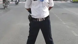 Polisi lalu lintas India Ranjeet Singh berpose saat berdiri di tengah jalan persimpangan Indore, India (22/12). Ranjeet Singh memiliki kumis bergaya Freddie Mercury namun suka menari moonwalk ala Michael Jackson. (AFP Photo/Indranil Mukherjee)