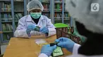 Pekerja lab mengemas serbuk hasil pengolahan laboratorium nano teknologi di balai penelitian dan pengembangan Kementan, Bogor, Jawa Barat, Selasa (7/7/2020). Balai penelitian ini melakukan penelitian terhadap Eucalyptus sebagai pencegah virus dalam jenis kategori jamu. (Liputan6.com/Herman Zakharia)