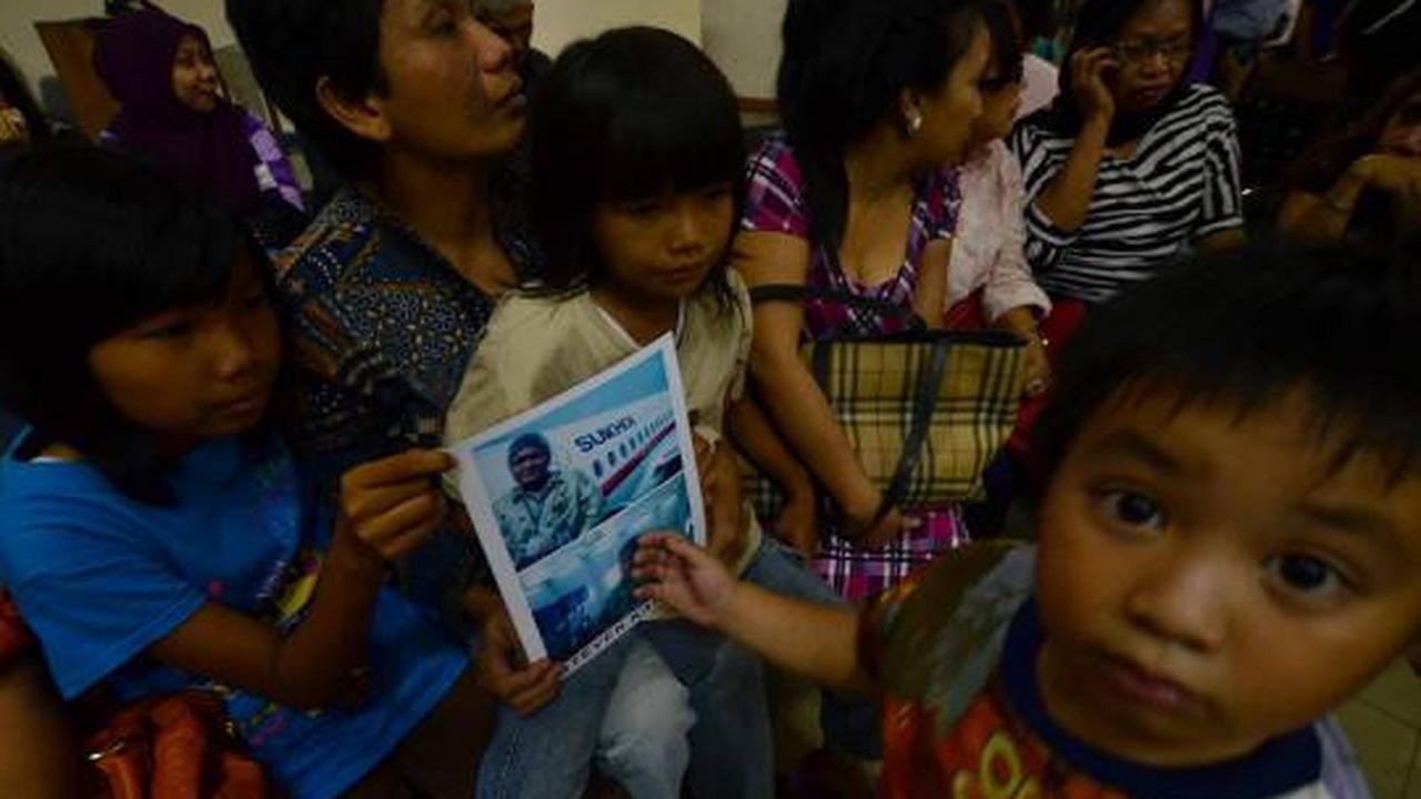 Putri dari Steven Kamagi memegang foto ayahnya yang ikut dalam penerba 