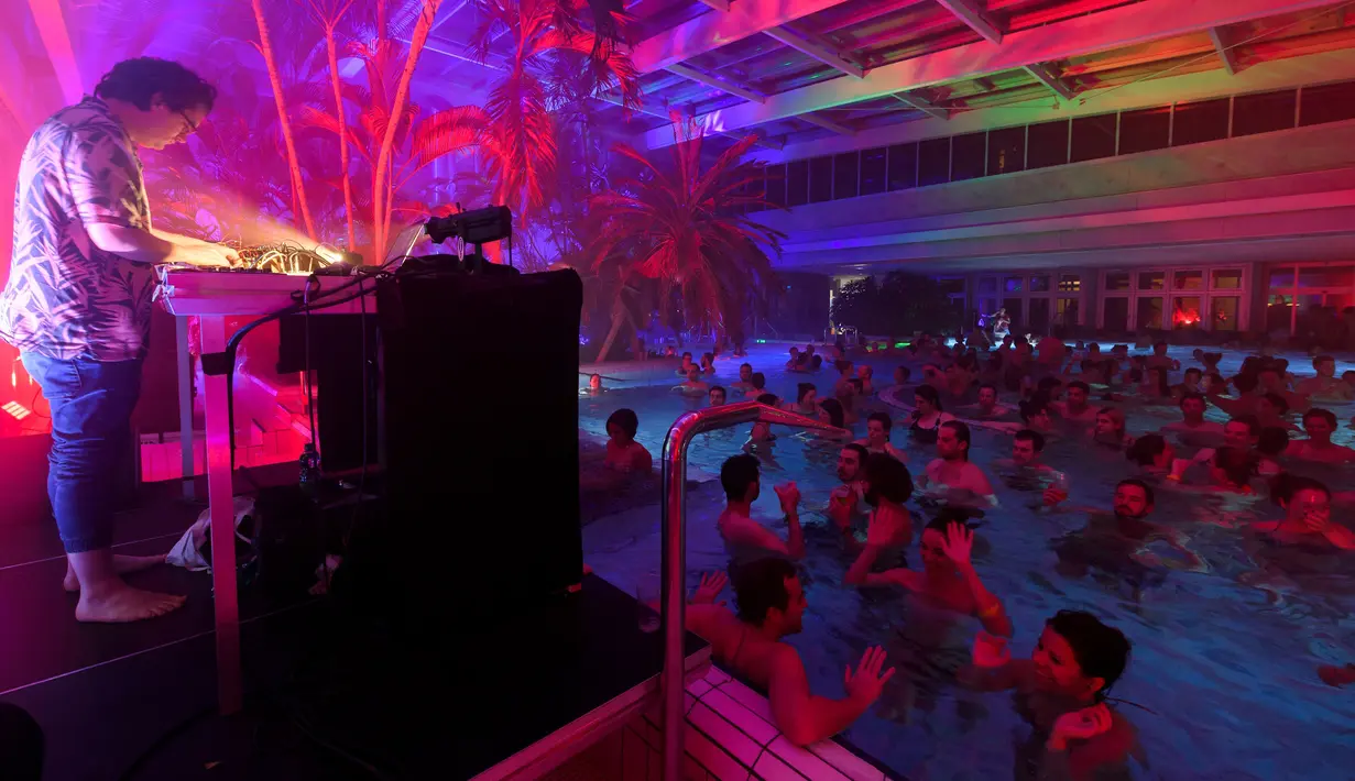 DJ Luke Abbott memainkan musik di kolam renang selama Festival Antigel di Confignon, Jenewa, Swiss (30/1). Festival ini menampilkan 104 pertunjukan pesta musik yang tersebar di 35 tempat-tempat tak terduga, di Canton Jenewa. (AFP Photo/Fabrice Coffrini)
