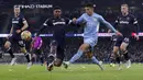 Bek Manchester City, Joao Cancelo mengumpan bola dari kawalan pemain West Ham United, Ben Johnson pada pertandingan lanjutan Liga Inggris di stadion Etihad, Inggris, Minggu (28/11/2021). City menang tipis atas West Ham 2-1. (AP Photo/Scott Heppell)