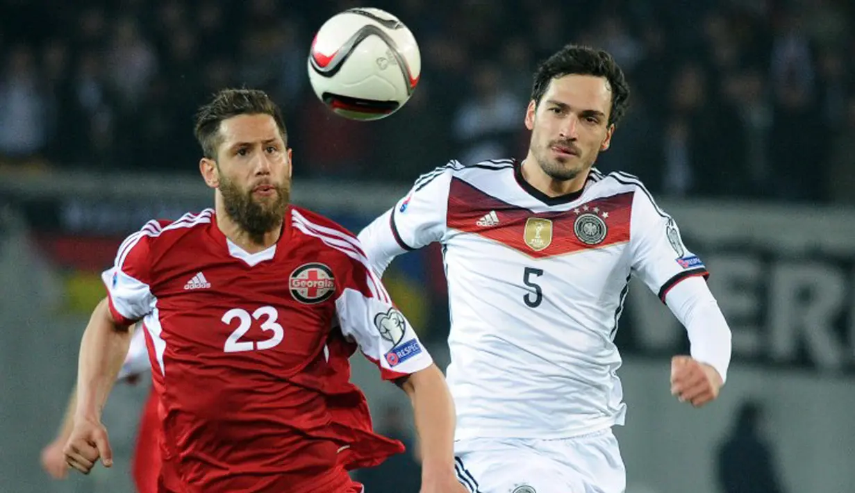 Penyerang Georgia, Levan Mchedlidze (kiri) berebut bola dengan bek Jerman Mats Hummels saat kualifikasi Piala Eropa 2016 di Locomotiv Stadium, Minggu (29/3/2015). Jerman menang 2-0 atas Georgia. (AFP PHOTO/Vano Shlamov)