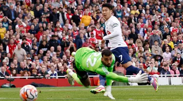 Pemain Tottenham Hotspur Son Heung-min mencetak gol ke gawang Arsenal yang dijaga oleh David Raya pada pertandingan sepak bola Liga Inggris di Emirates Stadium, London, Inggris, Minggu (24/9/2023). Pertandingan berakhir imbang dengan skor 2-2. (AP Photo/David Cliff)