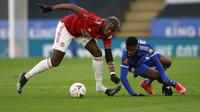 Gelandang MU, Paul Pogba berebut bola dengan striker Leicester City, Kelechi Iheanacho pada perempat final Piala FA di Stadion King Power, Inggris (22/3/2021). Dengan hasil ini, Leicester untuk pertama kalinya dalam 39 tahun terakhir lolos ke babak semi-final FA Cup. (AP Photo/Ian Walton, Pool)