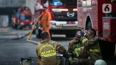 Petugas pemadam kebakaran beristirahat setelah melakukan pendingan di Gedung Kejaksaan Agung RI yang terbakar, Minggu (23/8/2020). Kebakaran di gedung Kejaksaan Agung pada Sabtu (22/8) malam akhirnya padam dan kini bangunan tersebut menyisakan bagian hitam legam. (Liputan6.com/Faizal Fanani)