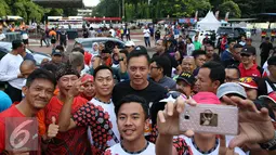 Calon Gubernur DKI Jakarta Agus Harimurti Yudhoyono berfoto selvie dengan warga Jakarta saat mengikuti kompetisi lari di CFD kawasan Senayan, Minggu (2/10). (Liputan6.com/Johan Tallo)