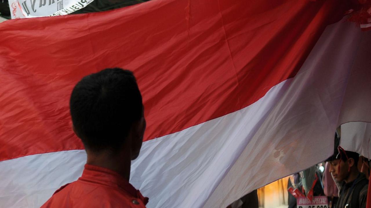 Warga melihat bentangan bendera merah putih yang dijual dengan aksesoris lainnya menjelang Hari Kemerdekaan Republik Indonesia ke-78 tahun di Pasar Jatinegara, Selasa (1/8/2023).