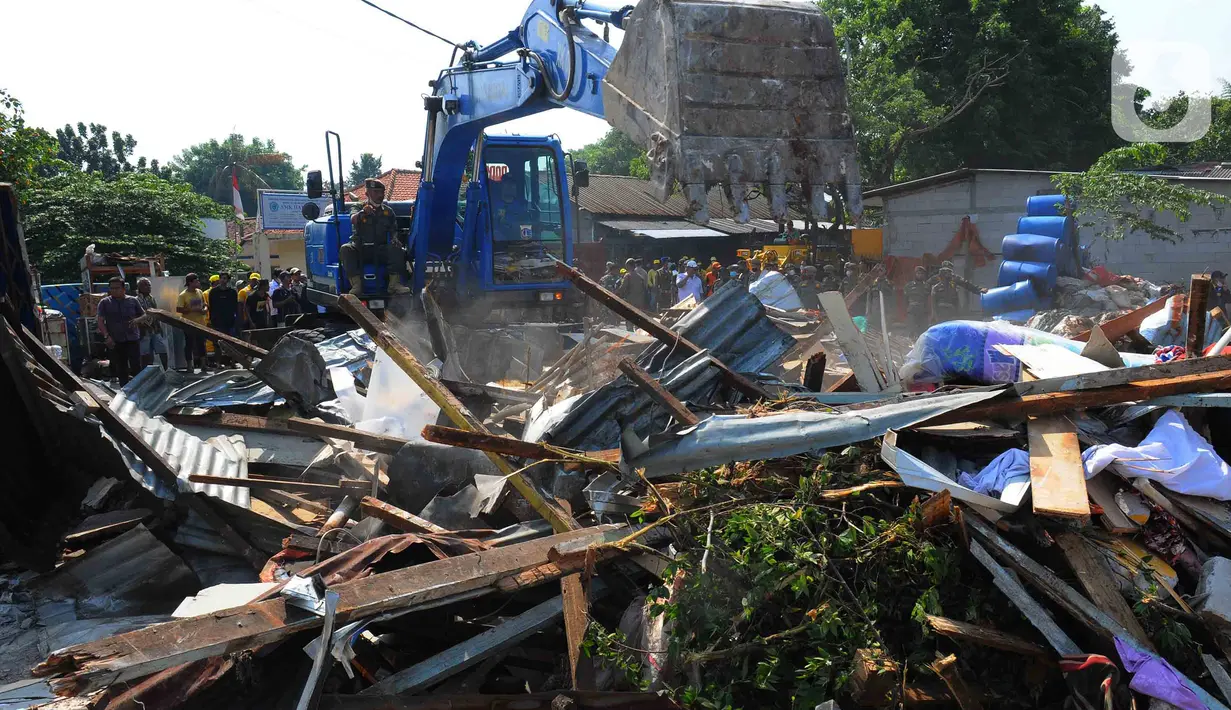 Petugas menggunakan alat berat menghancurkan bangunan yang terdampak proyek sodetan Ciliwung menuju Kanal Banjir Timur (KBT) di Kelurahan Cipinang Besar Selatan, Jakarta, Kamis (12/1/2023). Pemprov DKI mempercepat pembangunan sodetan kali Ciliwung menuju Kanal Banjir Timur (KBT) dengan tujuan mampu mengurangi dampak banjir dengan volume 60 kubik per detik. (merdeka.com/Imam Buhori)