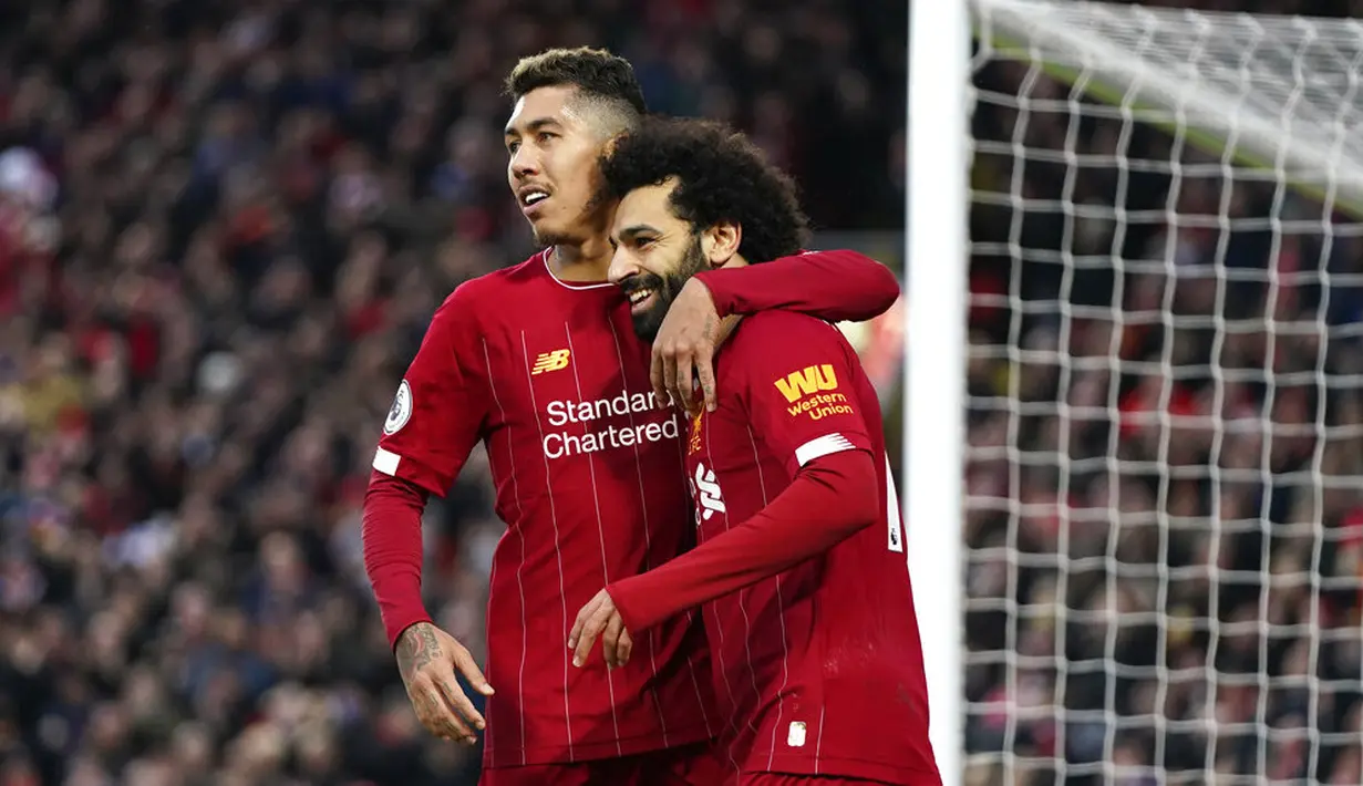 Pemain Liverpool, Mohamed Salah dan Roberto Firmino merayakan gol yang dicetak ke gawang Southampton pada laga Premier League di Stadion Anfield, Sabtu (1/2/2020). Liverpool menang 4-0 atas Southampton. (AP/Jon Super)