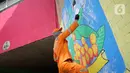 Petugas Penanganan Prasarana dan Sarana Umum (PPSU) Kelurahan Tebet Timur mempercantik tembok kolong jembatan Stasiun Kereta Api Cawang dengan membuat mural bernuansa kemerdekaan di Jakarta, Rabu (12/8/2020). Pembuatan mural untuk menyambut HUT ke-75 Kemerdekaan RI. (Liputan6.com/Immanuel Antonius)