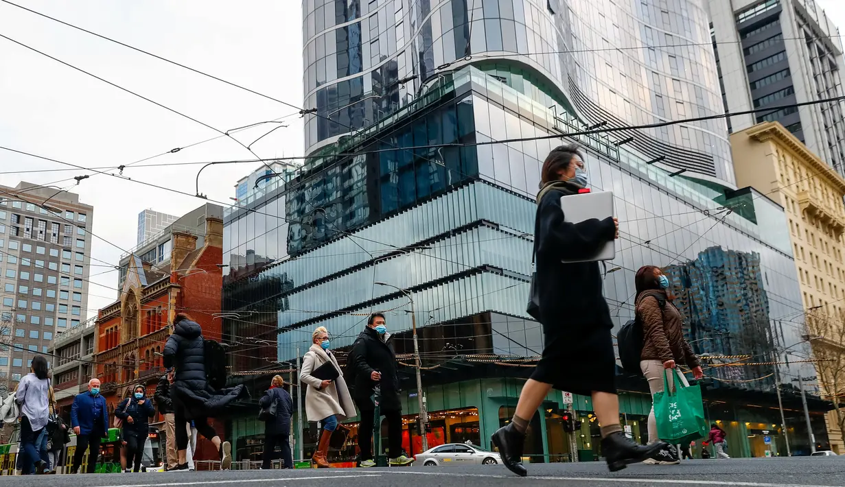 Orang-orang berjalan di sepanjang jalan di pusat kota Melbourne pada 5 Agustus 2021, ketika pihak berwenang mengumumkan lockdown (penguncian) untuk keenam kalinya di kota itu, Kamis (5/8/2021).  Lockdown di Melbourne tersebut guna mengendalikan penyebaran corona Covid varian delta. (Con Chronis/AFP)