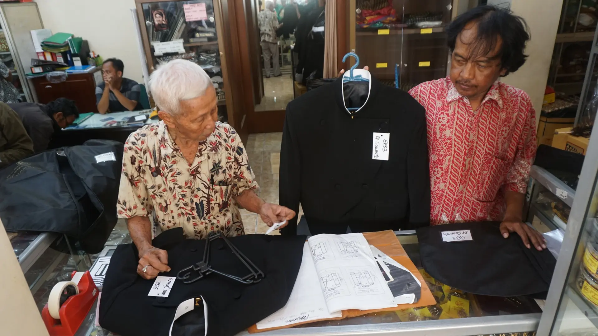 Karyawan penjahit Busana Jawi Suratman sedang menunjukkan pakaian beskap pesanan keluarga Presiden Jokowi, Selasa (10/10).(Liputan6.com/Fajar Abrori)