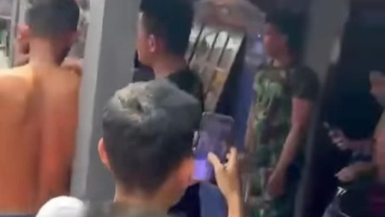 Pria berkostum baju loreng kembali masuk masuk rumah.