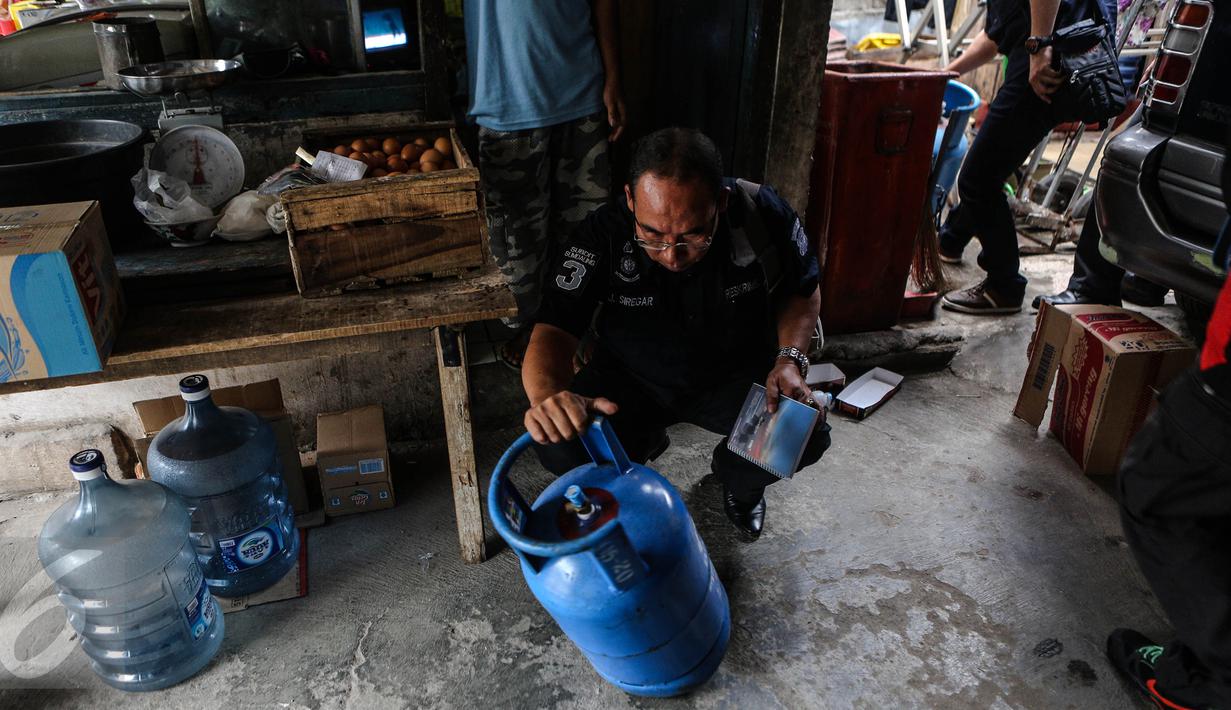 Petugas Krimsus Polda Metro Jaya memeriksa tabung gas elpiji 12 kg di kawasan Kebon Jeruk, Jakarta, Kamis (30/7/2015). Kasus ini bermula dari laporan warga ketika mengembalikan tabung gas yang diduga berisi air ke penjual. (Liputan6.com/Faizal Fanani)