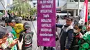 Pengemudi ojek online membentangkan spanduk tuntutan saat melakukan aksi di depan Balai Kota Jakarta, Rabu (8/2/2023). Dalam aksinya, mereka menolak penerapan jalan berbayar atau electronic road pricing (ERP) diterapkan di Jakarta. (Liputan6.com/Angga Yuniar)