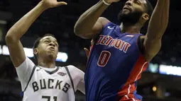 Aksi pemain Detroit Pistons, Andre Drummond (0) saat mencetak poin melewati adangan pemain Bucks, John Henson (31) pada laga NBA basketball game di Bradley Center, Milwaukee, (15/11/2017). Bucks menang 99-95. (AP/Aaron Gash)