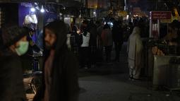 Orang-orang mengunjungi pasar, di mana beberapa pemilik toko menggunakan generator untuk penerangan selama pemadaman listrik nasional, di Islamabad, Pakistan, Senin, 23 Januari 2023. Puluhan juta orang di Pakistan tidak mendapat pasokan listrik dan ini merupakan “gangguan besar-besaran” kedua dalam tiga bulan terakhir. (AP Photo/K.M. Chaudary)