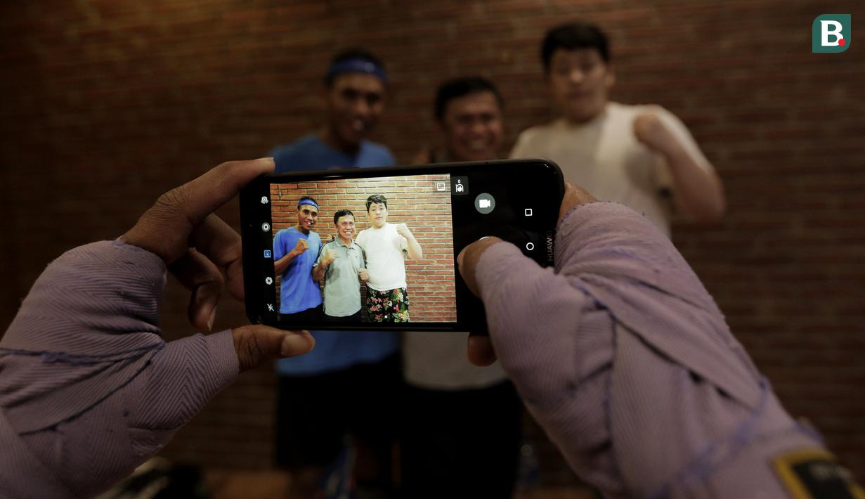 Legenda tinju Indonesia, Ellyas Pical, foto bersama petinju muda di Kawasan Bintaro, Jumat (13/7/2018). Ellyas Pical adalah petinju Indonesia pertama yang berhasil menjadi juara dunia. (Bola.com/M Iqbal Ichsan)