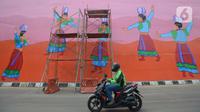 Pengendara motor melintas di Flyover 'Gaplek' Martadinata yang dipercantik dengan lukisan mural di Tangerang Selatan, Jumat (9/4/2021). Seni mural ini untuk memperindah suasana jalan kota. (merdeka.com/Imam Buhori)