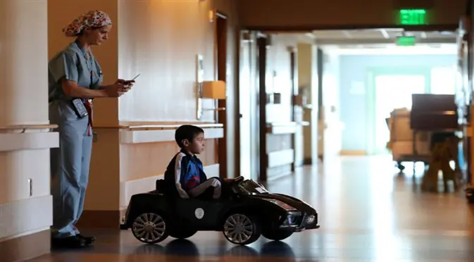 Orangtua pun lega saat anak sangat senang naik mobil menuju ruang operasi. (Foto: REUTERS/Mike Blake Reuters)