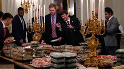 Para pemain Clemson Tigers mengambil makanan cepat saji di Gedung Putih, Washington, Senin (14 /1). Presiden AS Donald Trump menjamu tamunya dengan makanan cepat saji dari McDonald, Wendy, Burger King, Arby dan Domino. (AP Photo/Susan Walsh)