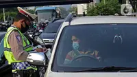 Polisi memeriksa surat kendaraan di kawasan Fatmawati, Jakarta, Senin (10/8/2020). Ditlantas Polda Metro Jaya kembali menerapkan sanksi tilang terhadap kendaraan roda empat yang melanggar peraturan ganjil genap di masa Pembatasan Sosial Berskala Besar (PSBB) transisi. (Liputan6.com/Herman Zakharia)