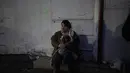 Seorang wanita pengungsi memegang anjingnya duduk di pinggir jalan mendekati perbatasan dengan Polandia di Shehyni, Ukraina, Minggu (6/3/2022). Jumlah orang Ukraina yang dipaksa meninggalkan negara mereka meningkat menjadi 1,5 juta. (AP Photo/Daniel Cole)