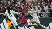 Lamine Yamal menggiring bola di samping Eduardo Camavinga dan Alvaro Carreras dalam laga final Piala Super Spanyol di King Abdullah Sports City Stadium, Jeddah, 12 Januari 2026. (AP Photo/Altaf Qadri)