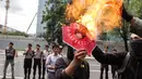 Massa aksi membakar poster Presiden AS Donald Trump saat unjuk rasa di depan kantor Kedubes AS di Jakarta Sabtu (4/2). Munculnya kebijakan Trump dianggap merugikan sebagian warga. (Liputan6.com/Fery Pradolo)