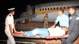 Seorang penumpang ditandu setelah pesawat maskapai India, Jet Airways, tergelincir di Bandara Dabolim, Goa, Selasa (27/12). Pesawat itu tergelincir hingga keluar landasan saat akan lepas landas. (Indian Navy/Indian Ministry of Defence/Handout via REUTERS)