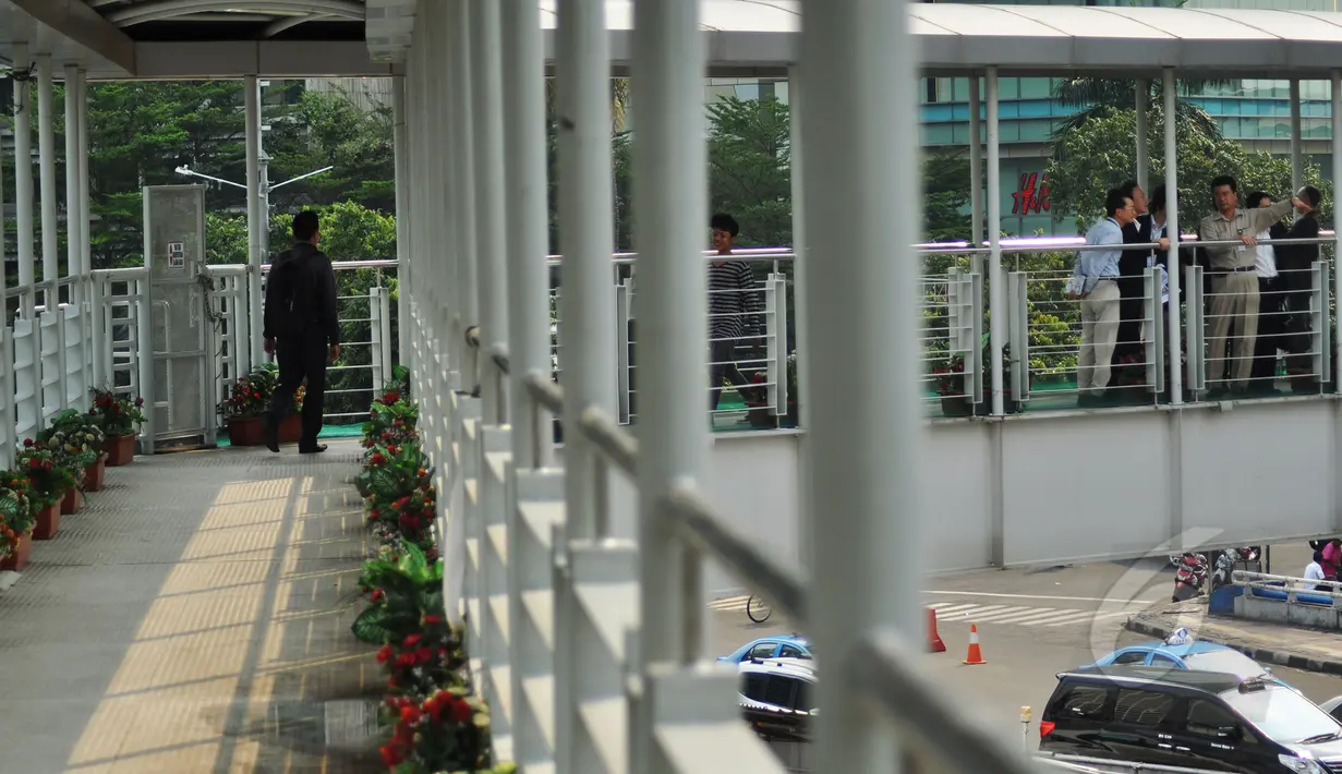 Sejumlah orang menyeberang melalui Jembatan Penyeberangan Orang (JPO)  Bundaran HI, Jakarta, Jumat (20/3/2015). Pemprov DKI akan menjadikan JPO di kawasan Bundaran HI sebagai standar JPO yang ada di Jakarta nanti. (Liputan6.com/Faizal Fanani)