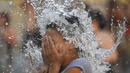 Seorang anak melakukan pendinginan di tengah gelombang panas musim panas di Buenos Aires, Argentina (14/1/2022). Fenomena gelombang panas di Argentina sudah diperkirakan mencapai puncaknya pada minggu ini dengan temperatur mencapai 40 derajat celcius. (AP Photo/Mario De Fina)