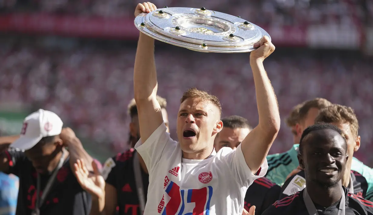 Selebrasi gelandang Bayern Munchen, Joshua Kimmich dengan mengangkat trofi Liga Jerman 2022/2023 setelah berakhirnya laga pekan terakhir menghadapi FC Cologne di Cologne, Jerman (27/5/2023). Kemenangan 2-1 atas FC Cologne memastikan Bayern Munchen merebut gelar Liga Jerman 2022/2023. (AP Photo/Matthias Schrader)
