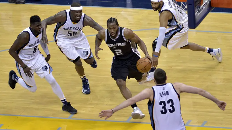 Forward San Antonio Spurs Kawhi Leonard (2) melewati kepungan pemain Memphis Grizzlies pada pertandingan di FedExForum, Jumat (28/4/2017) pagi WIB. Spurs menang 103-96. 