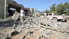 Sejumlah orang berdiri di puing penjara al-Zaydiyah yang hancur terkena serangan jet tempur koalisi pimpinan Arab Saudi di Yaman, Minggu (30/10). Menurut sejumlah sumber medis, puluhan orang tewas dalam serangan itu. (REUTERS/Abduljabbar Zeyad)