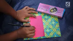 Seorang anak menuliskan cita-citanya di secarik kertas di jalur banjir kanal barat Tanah Abang, Jakarta, Senin (31/7). Selain itu kegiatan tersebut juga untuk menyambut bulan kemerdekaan RI. (Liputan6.com/Faizal Fanani)