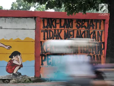 Pengendara melintasi mural bertema 'Tolak Kekerasan Perempuan dan Pelecehan Seksual' di kawasan Jatinegara, Jakarta, Senin (17/12). Mural tersebut dibuat untuk meningkatkan kesadaran akan ancaman bahaya pelecehan seksual. (Merdeka.com/Iqbal S. Nugroho)