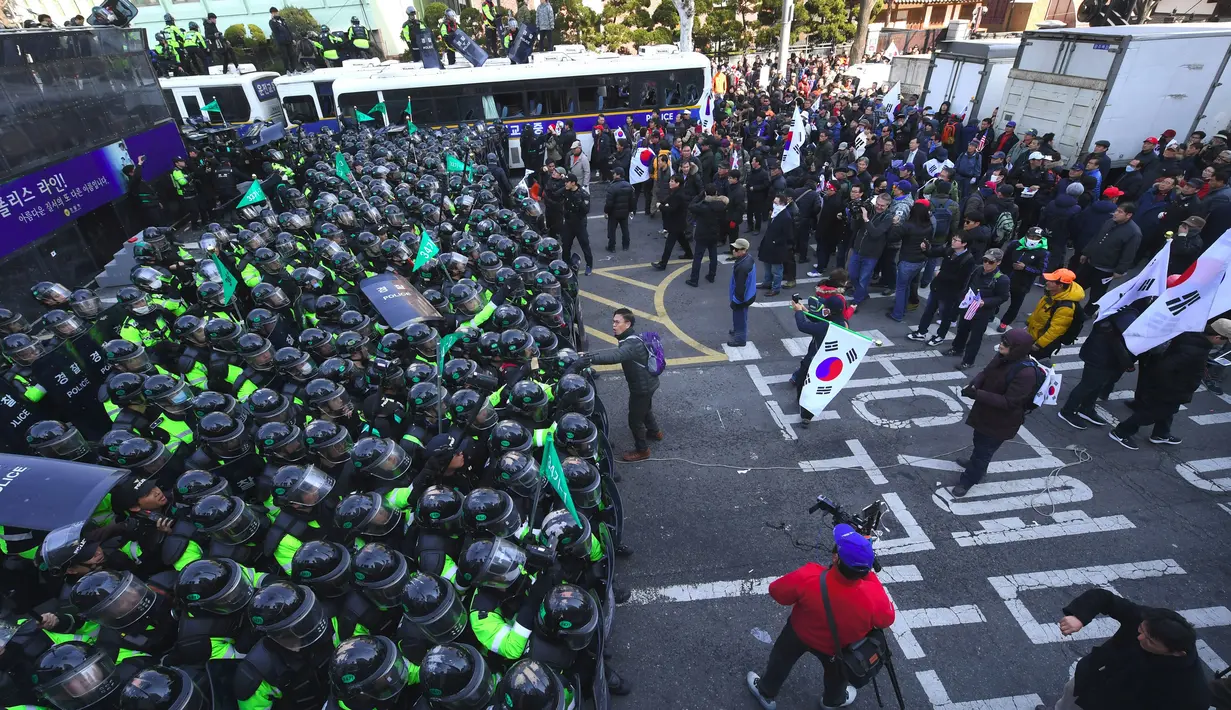 Polisi anti huru-hara dikerahkan dalam unjuk rasa pemakzulan Presiden Korsel, Park Geun-hye, di Seoul, Jumat (10/3). Pemakzulan Presiden Park yang dikeluarkan Mahkamah Konstitusi memicu aksi unjuk rasa yang berakhir bentrokan. (JUNG Yeon-Je/AFP)