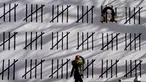 Seorang wanita pejalan kaki melihat mural baru karya seniman misterius Inggris, Banksy di wilayah Manhattan, New York (15/3). Mural ini memprotes penahanan seniman Turki Zehra Dogan karena lukisannya. (AFP Photo/Timothy A. Kliit)