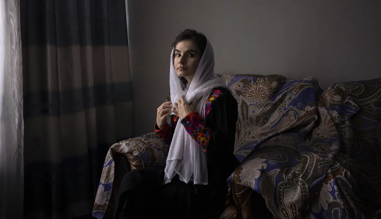 Asita Ferdous duduk di dalam rumahnya di Kabul, Afghanistan pada 10 November 2021. Dia adalah direktur Ariana Cinema tetapi tidak diizinkan memasuki bioskop karena Taliban memerintahkan pegawai pemerintah wanita untuk menjauh dari tempat kerja mereka. (AP Photo/Bram Jansen)
