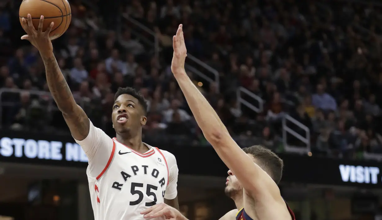 Pemain Toronto Raptors, Delon Wright (55) melakuykan layup saat diadang pemain Cavaliers, Ante Zizic (41) pada lanjutan NBA basketball game di Quicken Loans Arena, (21/3/2018) Cleveland. Cavs menang 132-129. (AP/Tony Dejak)