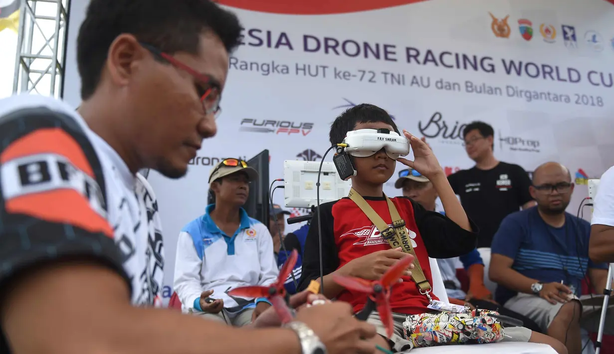 Seorang pilot  muda memakai kacamata headset FPV-nya sebelum menerbangkan drone balapnya selama acara FAI Drone Racing World Cup di Denpasar di pulau resor Indonesia di Bali (7/4). (AFP Photo/Sonny Tumbelaka)
