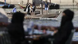 Orang Emirat terlihat sebagai perahu yang membawa turis berlayar di suaka margasatwa Ras Al-Khor dekat kawasan tua kota Teluk Dubai (6/1/2021).  Cagar ini memiliki banyak burung, crustacea, sedikit mamalia dan ikan. (AFP/Karim Sahib)