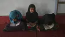 Anak-anak membaca Alquran selama bulan suci Ramadhan di sebuah masjid di pinggiran Kabul, Afghanistan, Selasa (27/4/2021).  Bulan Ramadhan menjadi momen untuk memperbanyak amalan, termasuk ketekunan menjalani tadarus Alquran. (WAKIL KOHSAR / AFP)