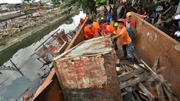Petugas Satpol PP saat mengangkat bangunan liar ke dalam truk di Jalan Subur Baru, Jakarta, Senin (23/2/2015). Pemprov DKI Jakarta bertujuan melakukan pelebaran jalan dari empat meter menjadi tujuh meter.(Liputan6.com/Faizal Fanani)